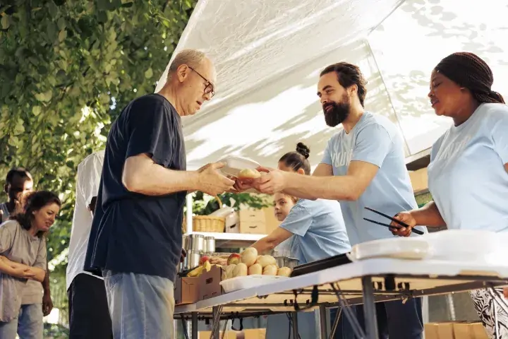 Volunteers serving food to community members at a local charity event